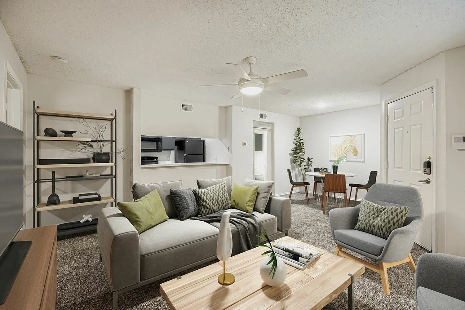 Living room with gray sofa, wood-style plank flooring, ceiling fan, dining chairs, shelving unit