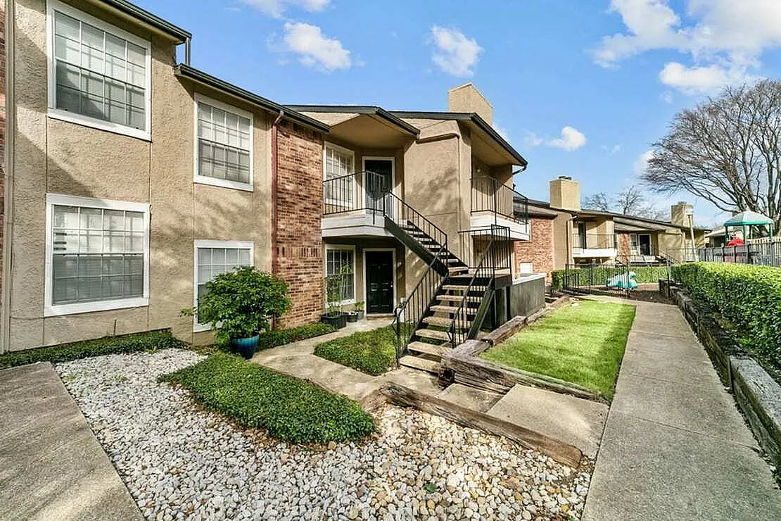 Multi-unit residential building, brick and stucco facade, exterior stairs, manicured landscaping, Garland TX