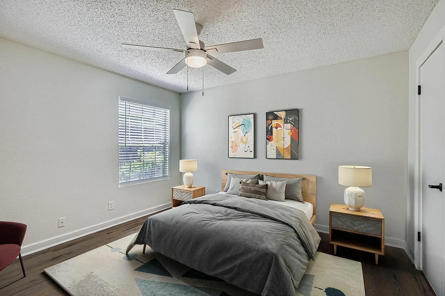 Primary bedroom, wood-style plank flooring, ceiling fan, nightstands with lamps