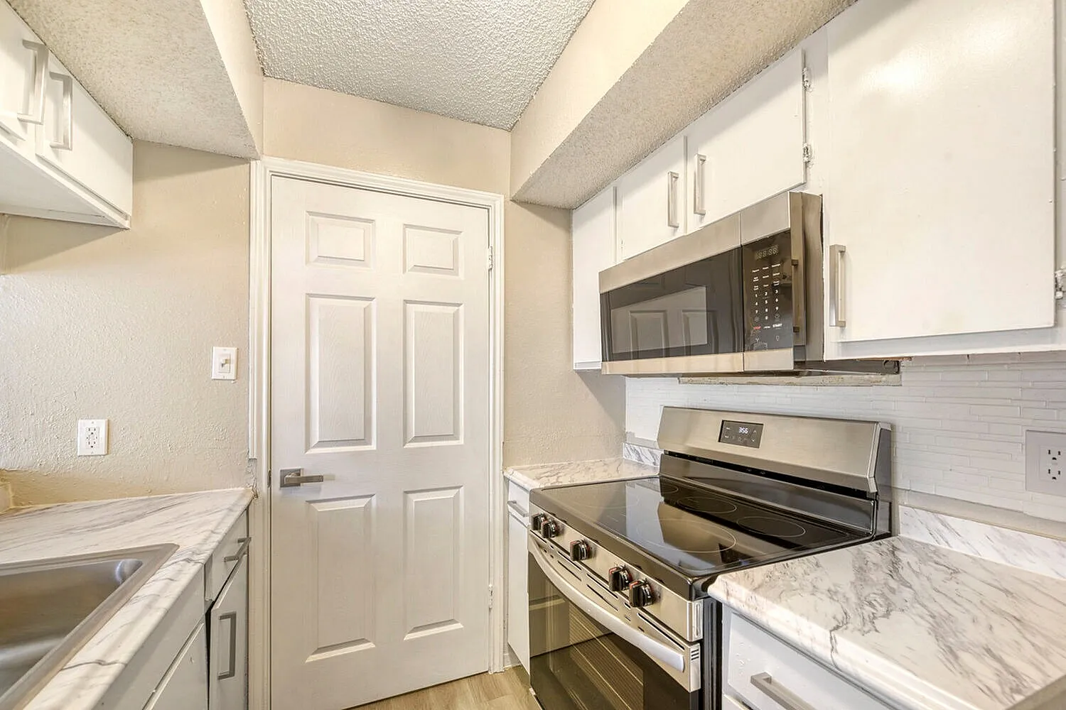 Kitchen, white shaker cabinetry, marble countertops, stainless appliances, subway tile backsplash