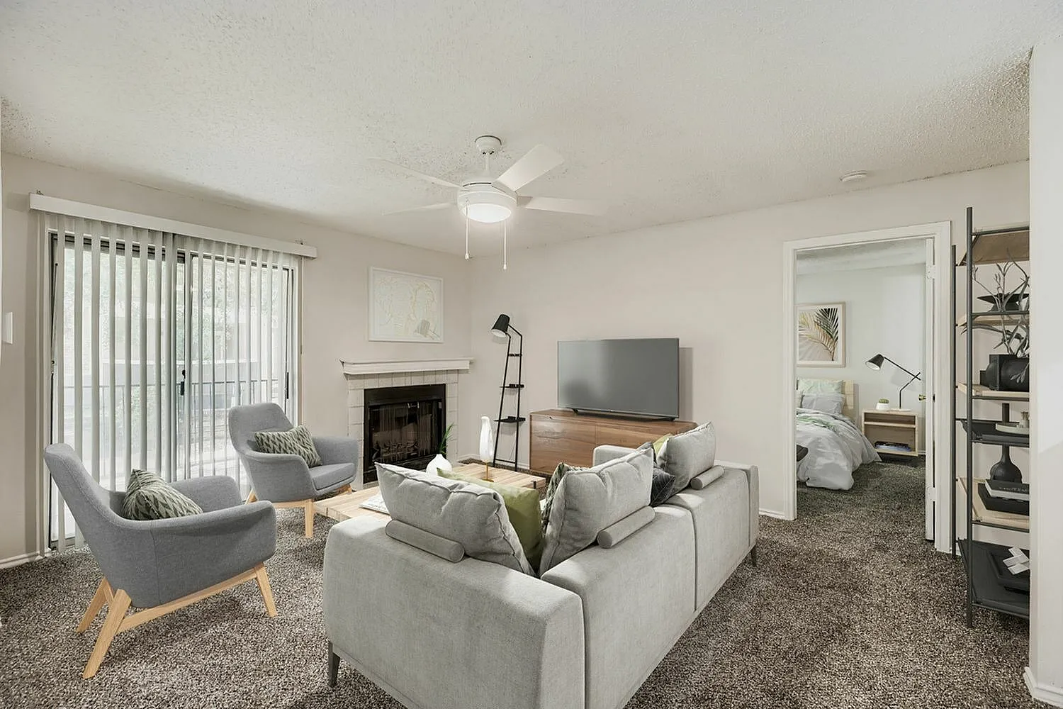 Living room with wood-style plank flooring, beige sectional sofa, ceiling fan, fireplace with mantel