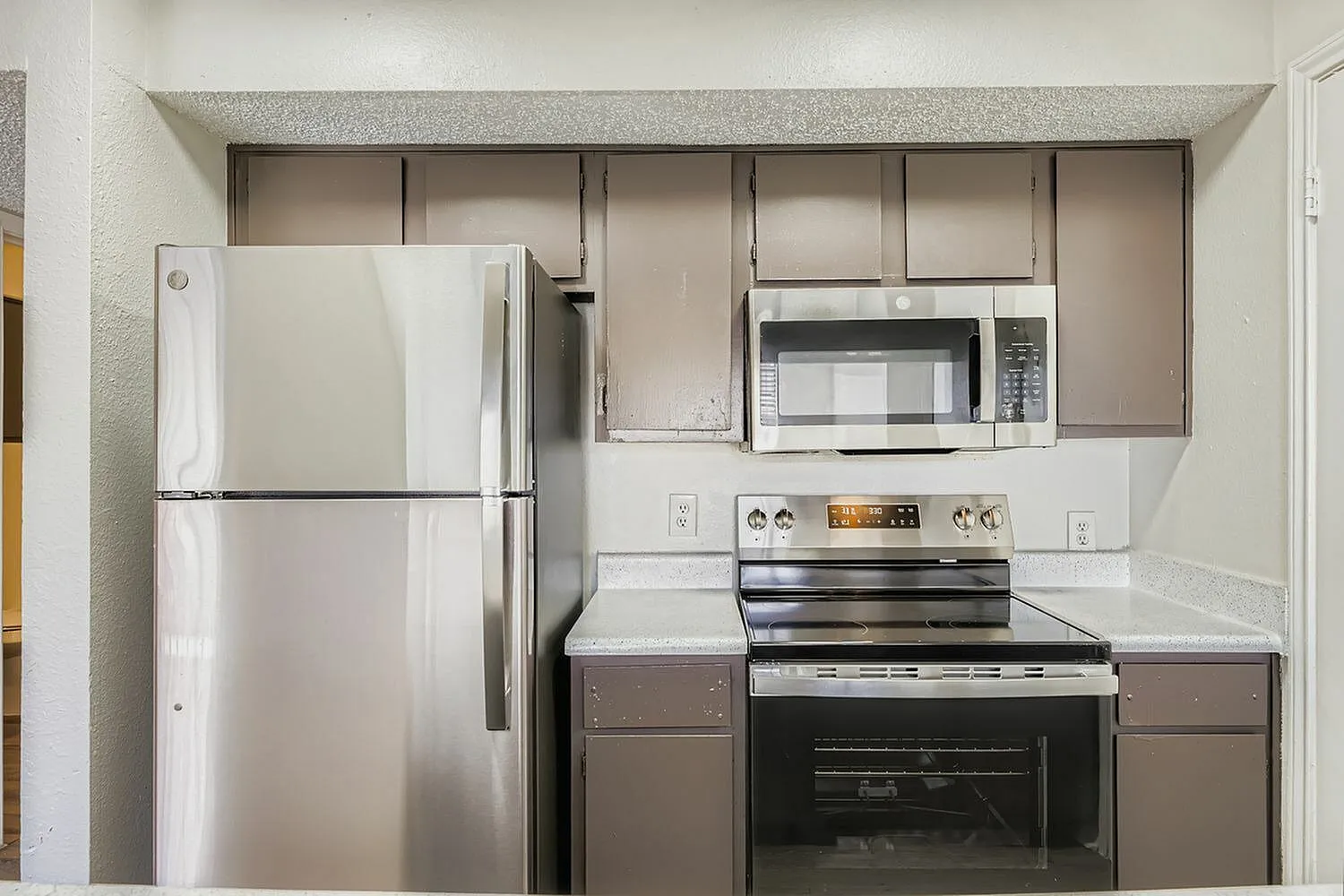 Kitchen, gray shaker cabinetry, stainless steel appliances, white countertops, upper storage cabinets