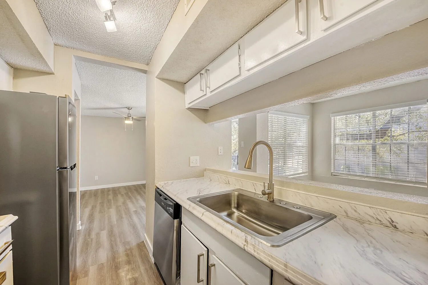 Kitchen, marble countertops, stainless steel sink, shaker cabinetry, wood-style plank flooring, windows