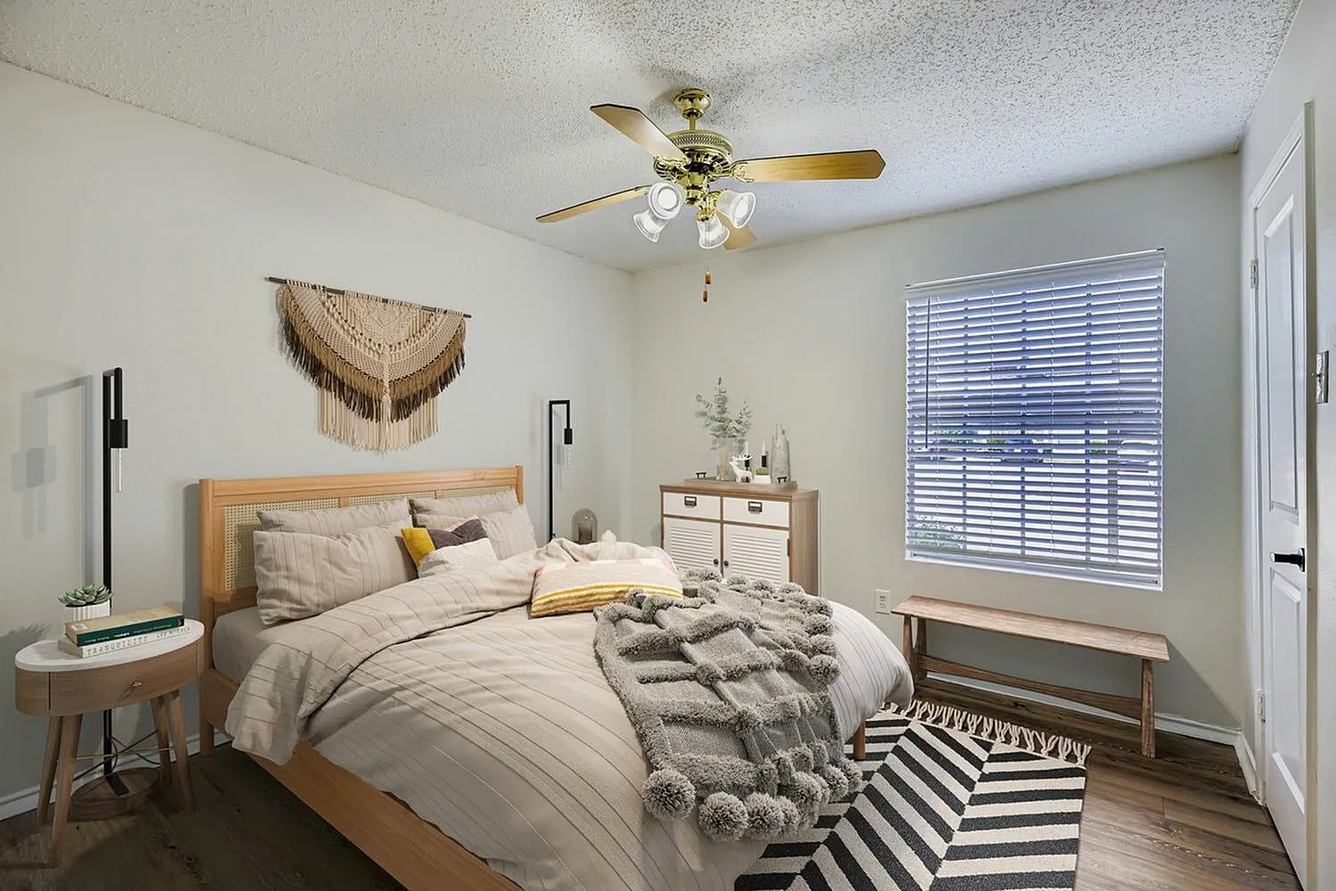 Primary bedroom, wood-style plank flooring, ceiling fan with lights, window with plantation shutters