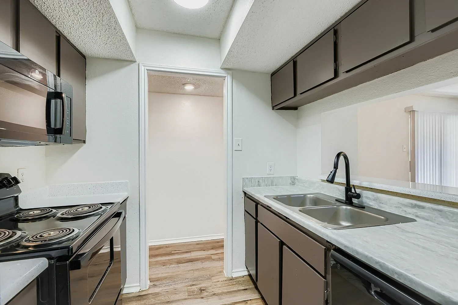 Kitchen, gray shaker cabinetry, quartz countertops, stainless appliances, wood-style plank flooring