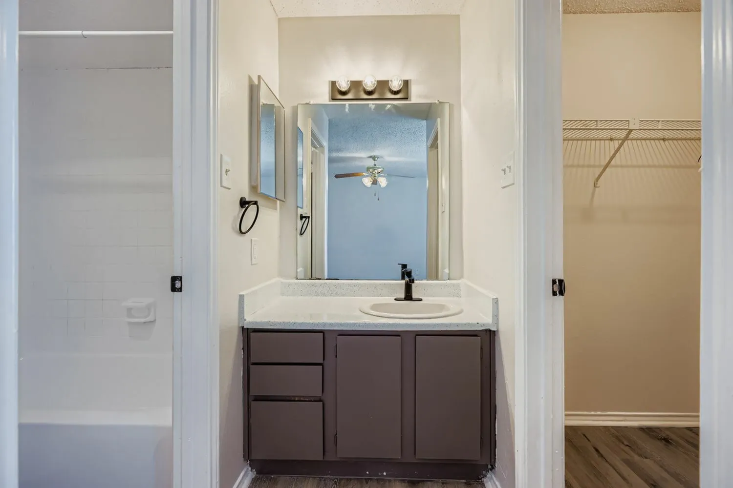 Bathroom, dark wood vanity, white countertop, framed mirror, chrome fixtures