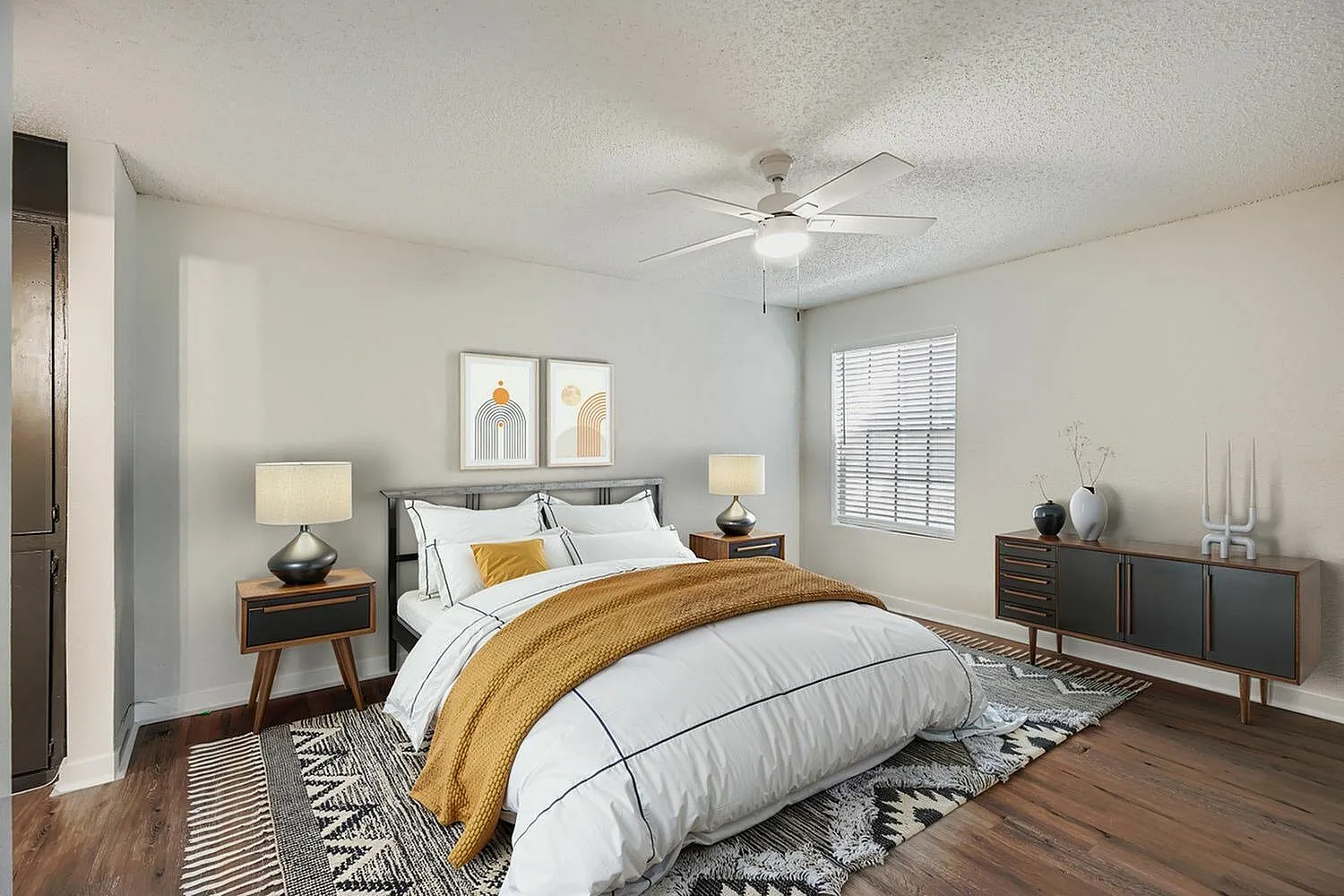 Primary bedroom, wood-style plank flooring, ceiling fan, mid-century nightstands