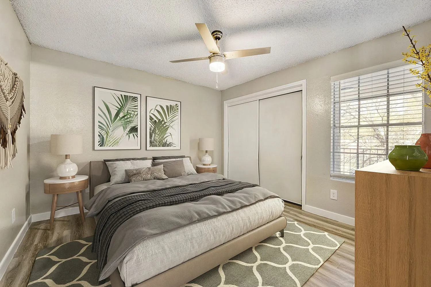 Primary bedroom, wood-style plank flooring, ceiling fan, botanical wall art