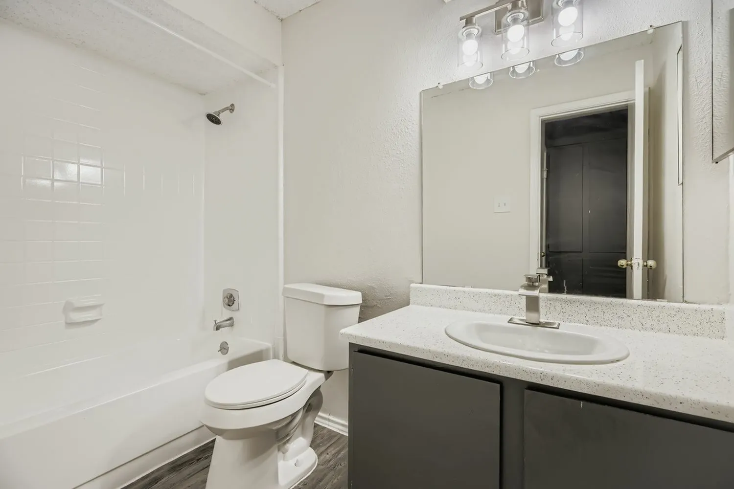 Bathroom, dark cabinetry, quartz countertops, vessel sink, mirror with lighting