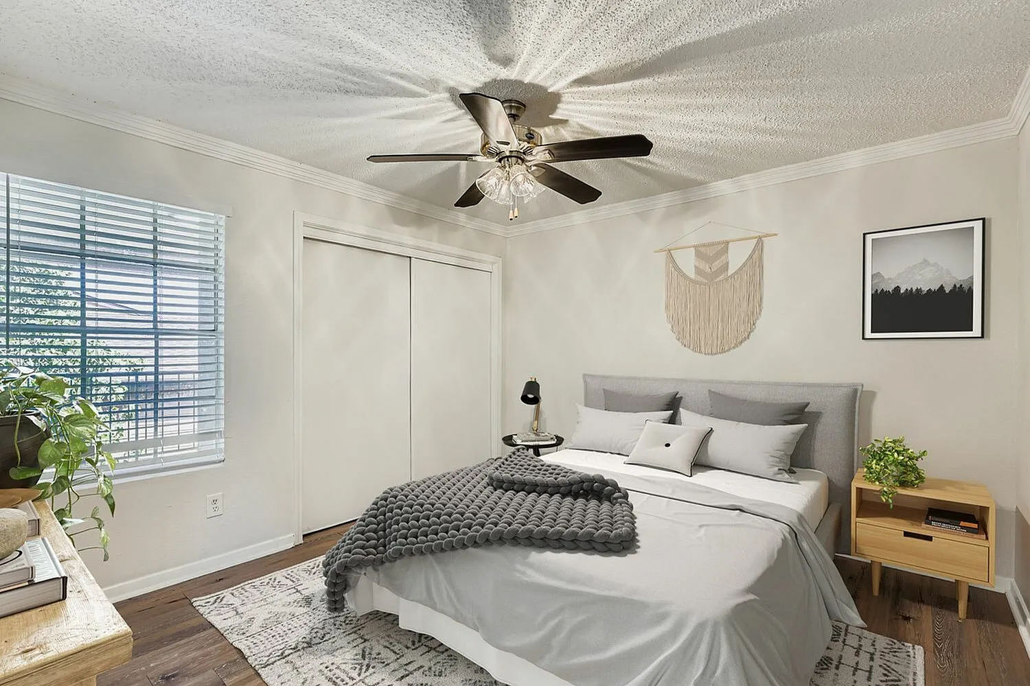 Primary bedroom, gray upholstered headboard, wood-style plank flooring, ceiling fan with light fixture