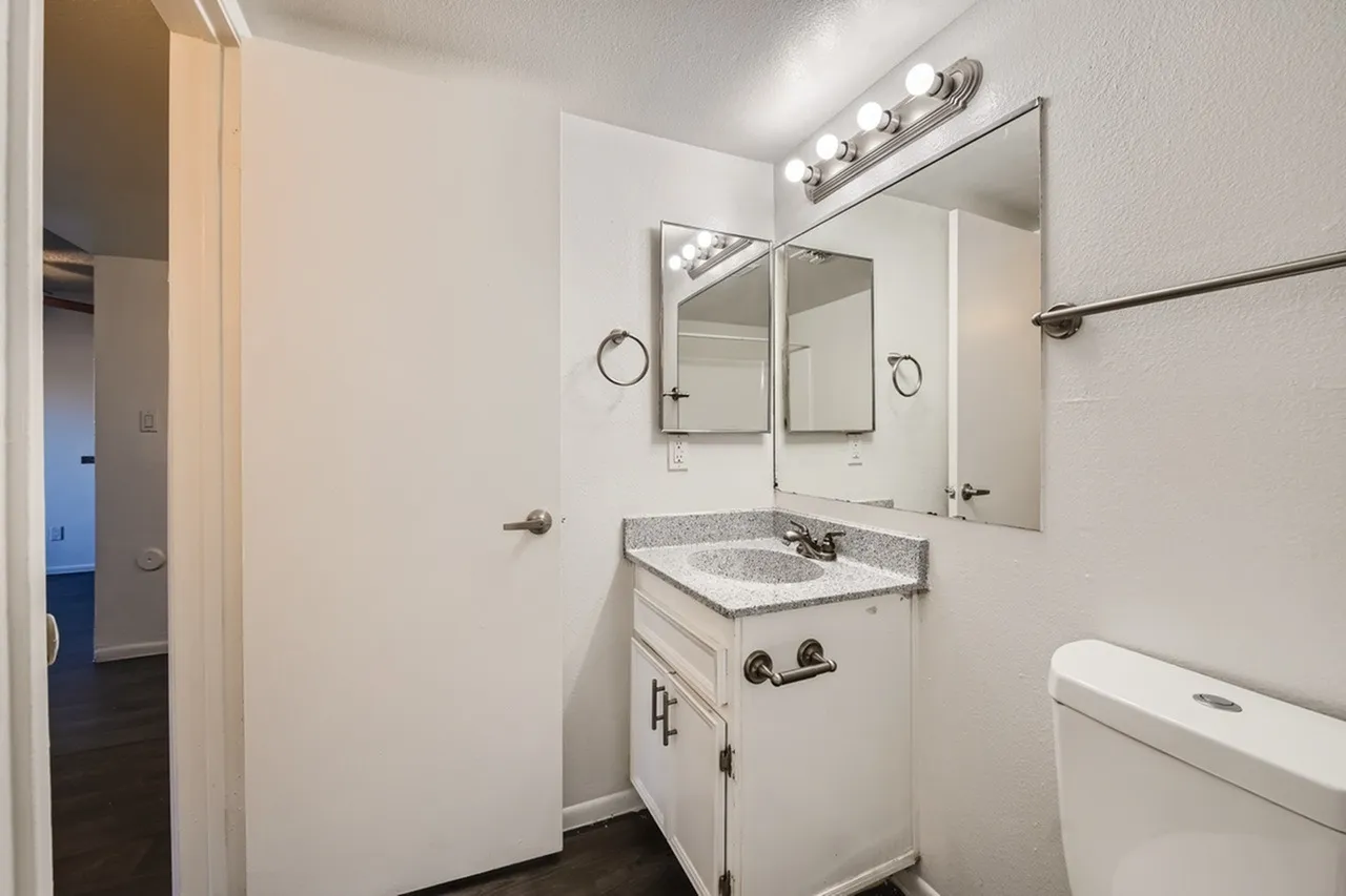 Bathroom, granite countertop, double vanity mirror, wall sconce lighting, tile flooring