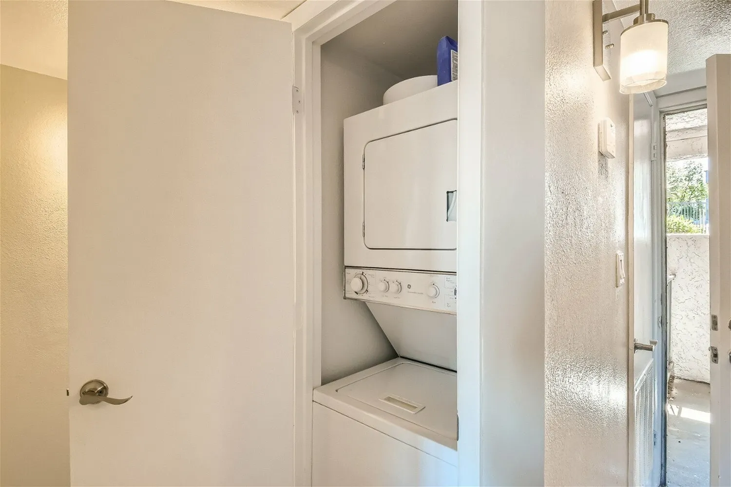 Laundry room, stacked washer dryer combo, white cabinetry, recessed lighting