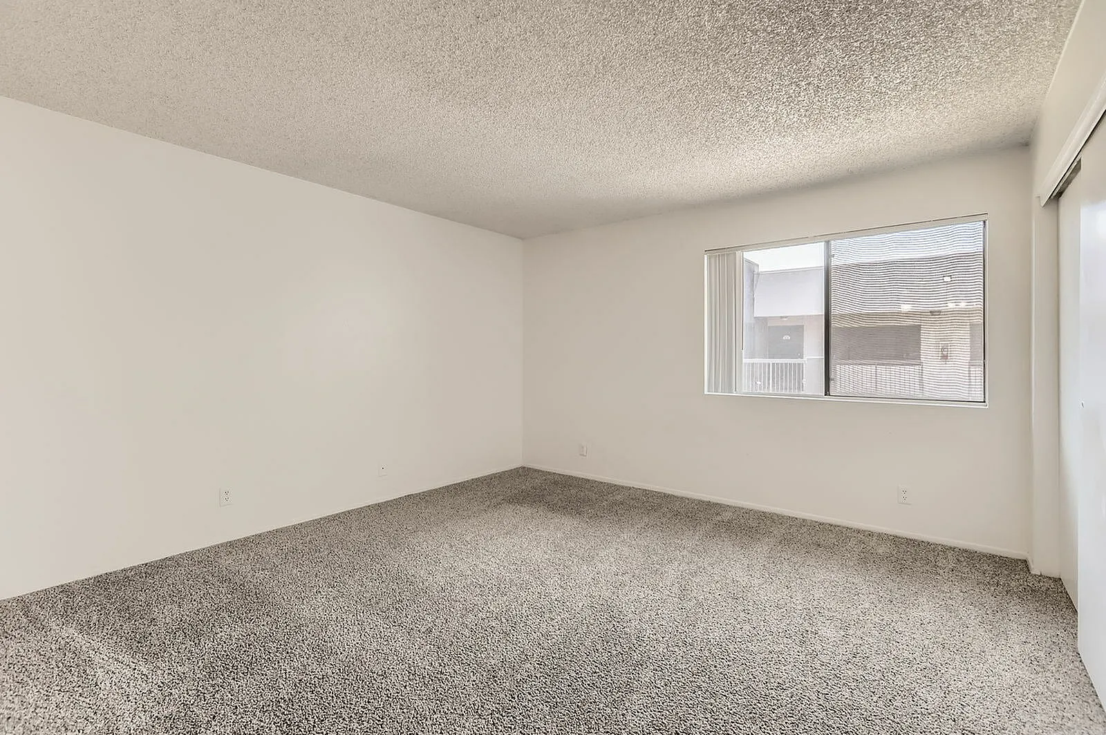 Bedroom, gray carpet flooring, textured ceiling, window with vertical blinds