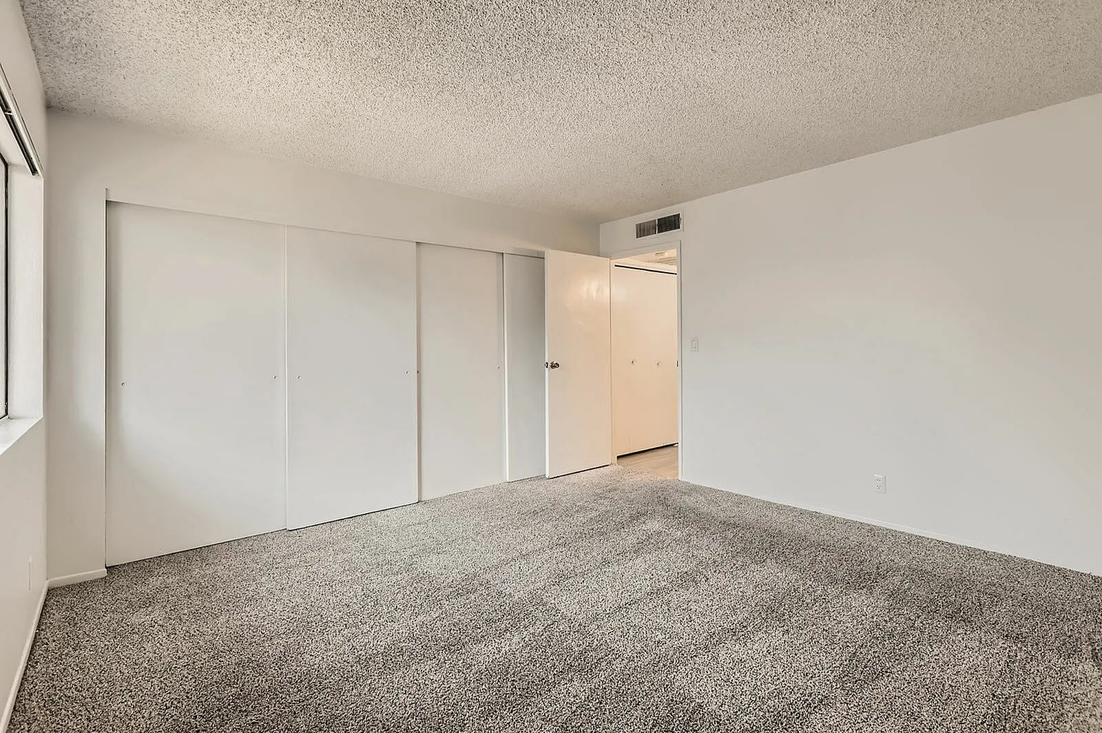 Bedroom, gray carpet flooring, built-in closet with sliding doors, window