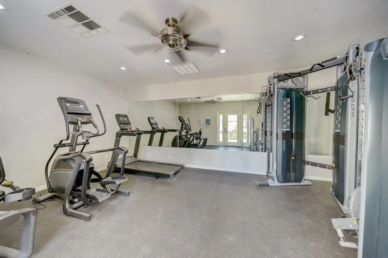 Fitness center, exercise equipment, cardio machines, weight machines, concrete flooring