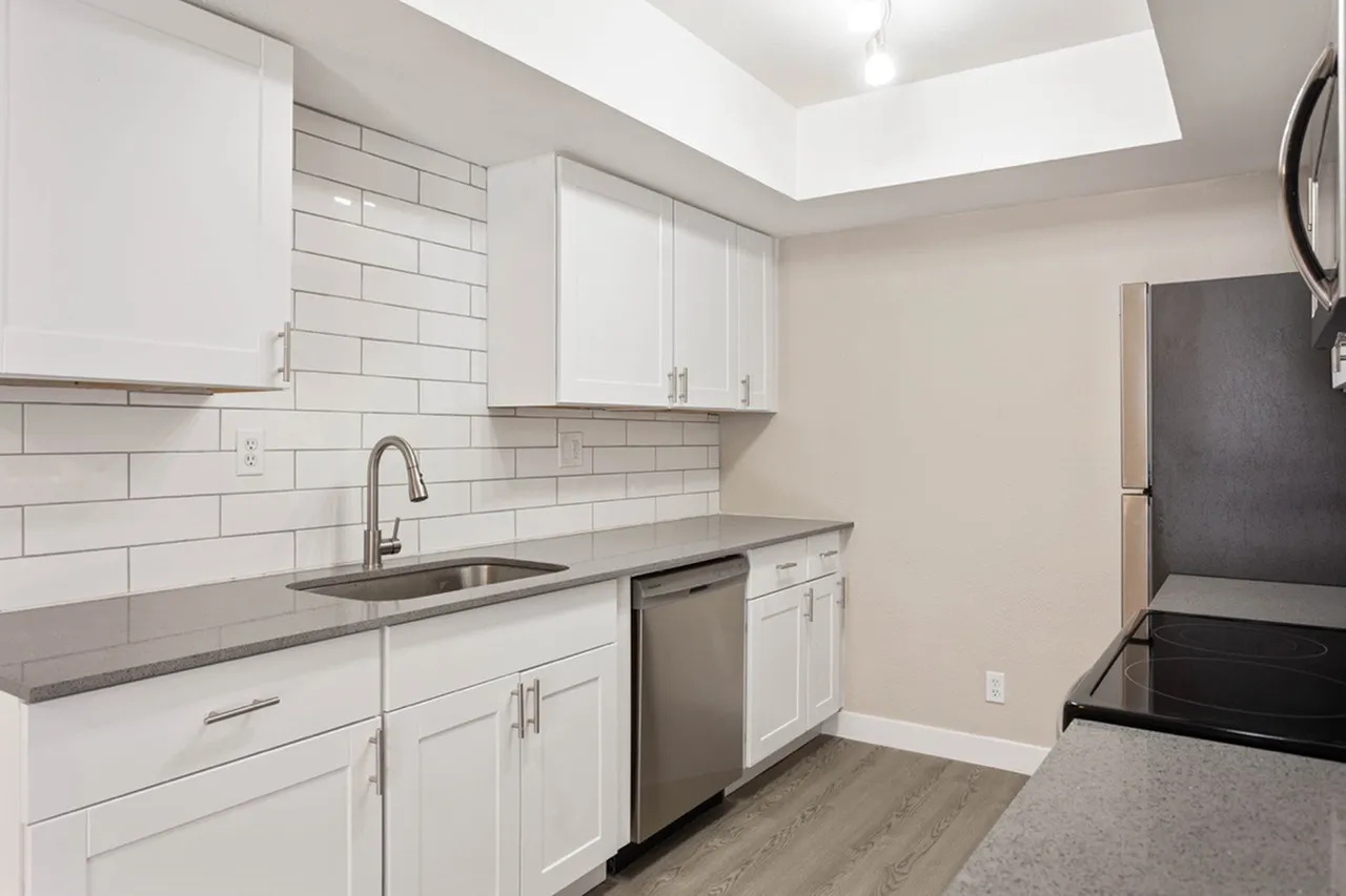 Kitchen, white shaker cabinetry, gray quartz countertops, stainless steel appliances, white subway tile backsplash, wood-style plank flooring