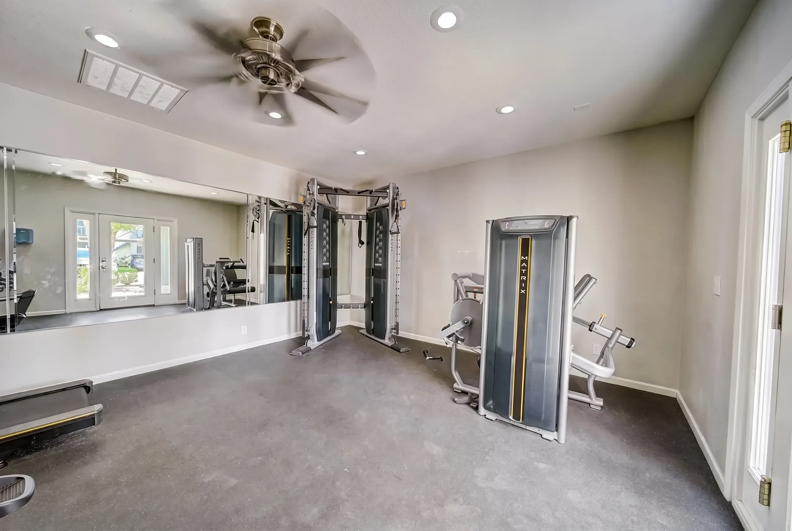 Fitness center, cable machines, mirrored walls, ceiling fan, recessed lighting