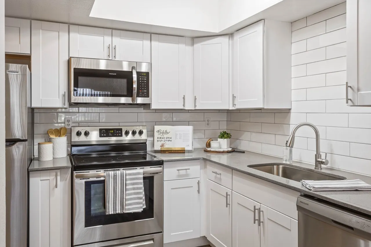 Kitchen, white shaker cabinetry, gray subway tile backsplash, stainless steel appliances, quartz countertops