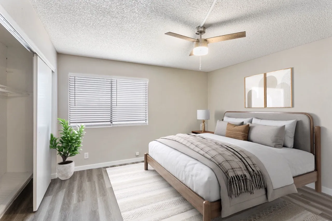 Primary bedroom, wood-style plank flooring, ceiling fan, upholstered bed frame, natural lighting from window
