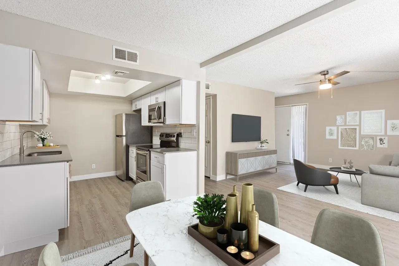 Open kitchen and living area, white cabinetry, stainless appliances, quartz countertops, wood-style plank flooring
