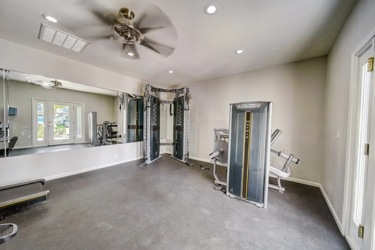 Fitness center, cable machines, mirrored walls, ceiling fan, recessed lighting