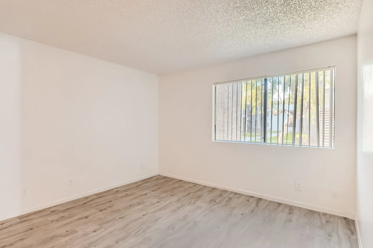 Bedroom, wood-style plank flooring, vertical blinds, textured ceiling