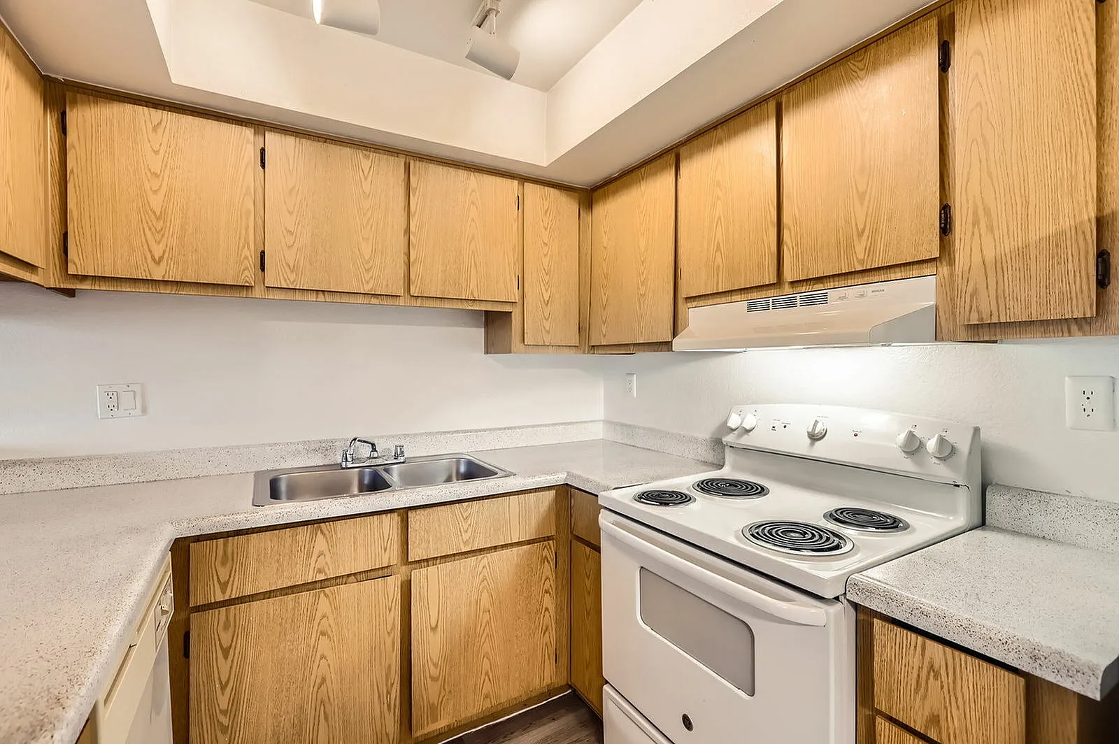 Kitchen, oak cabinetry, white appliances, quartz countertops, white backsplash
