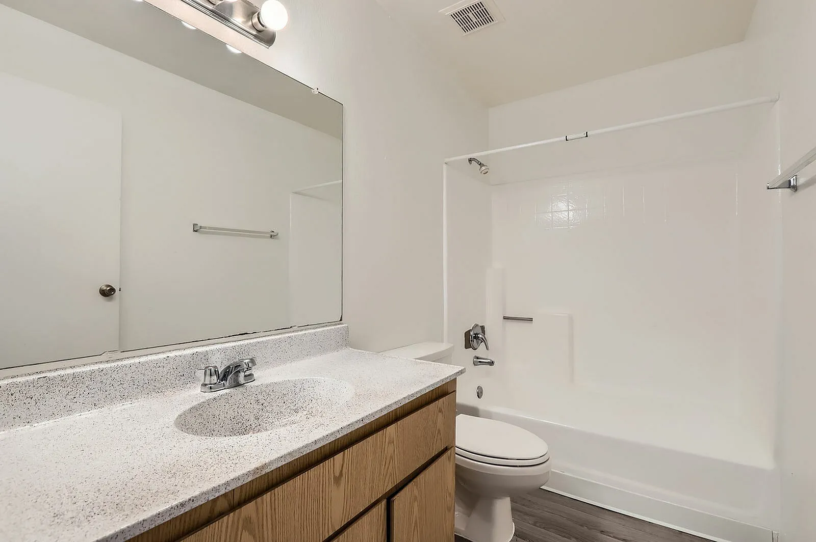 Bathroom, quartz countertops, wood vanity cabinetry, single sink, large mirror