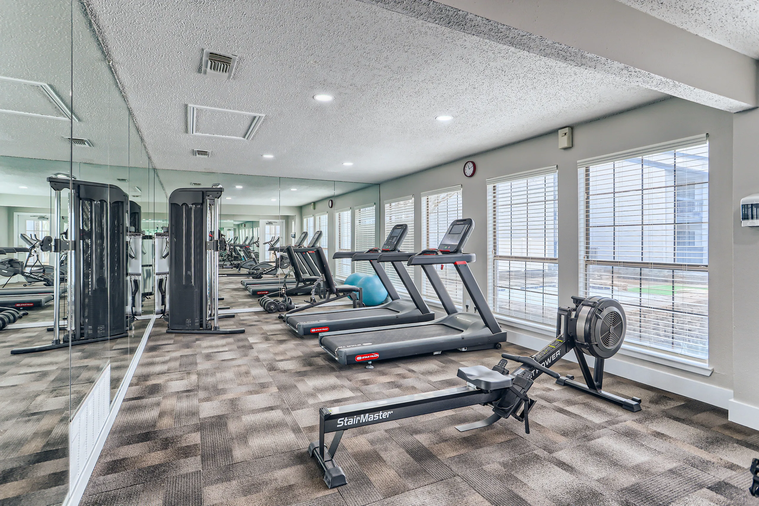 Fitness center featuring cardio machines and free weights