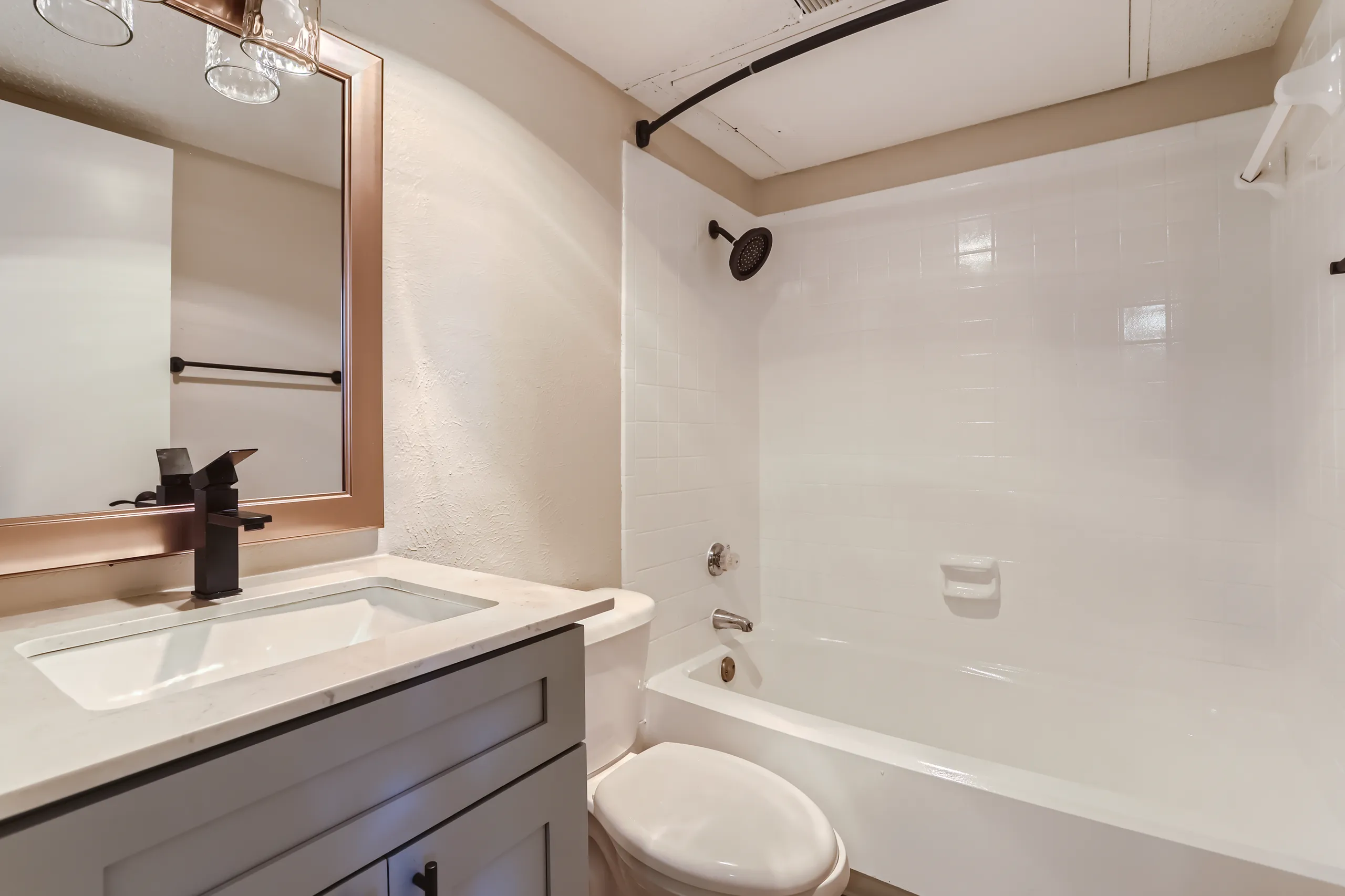 Updated apartment bathroom with quartz vanity and matte black fixtures