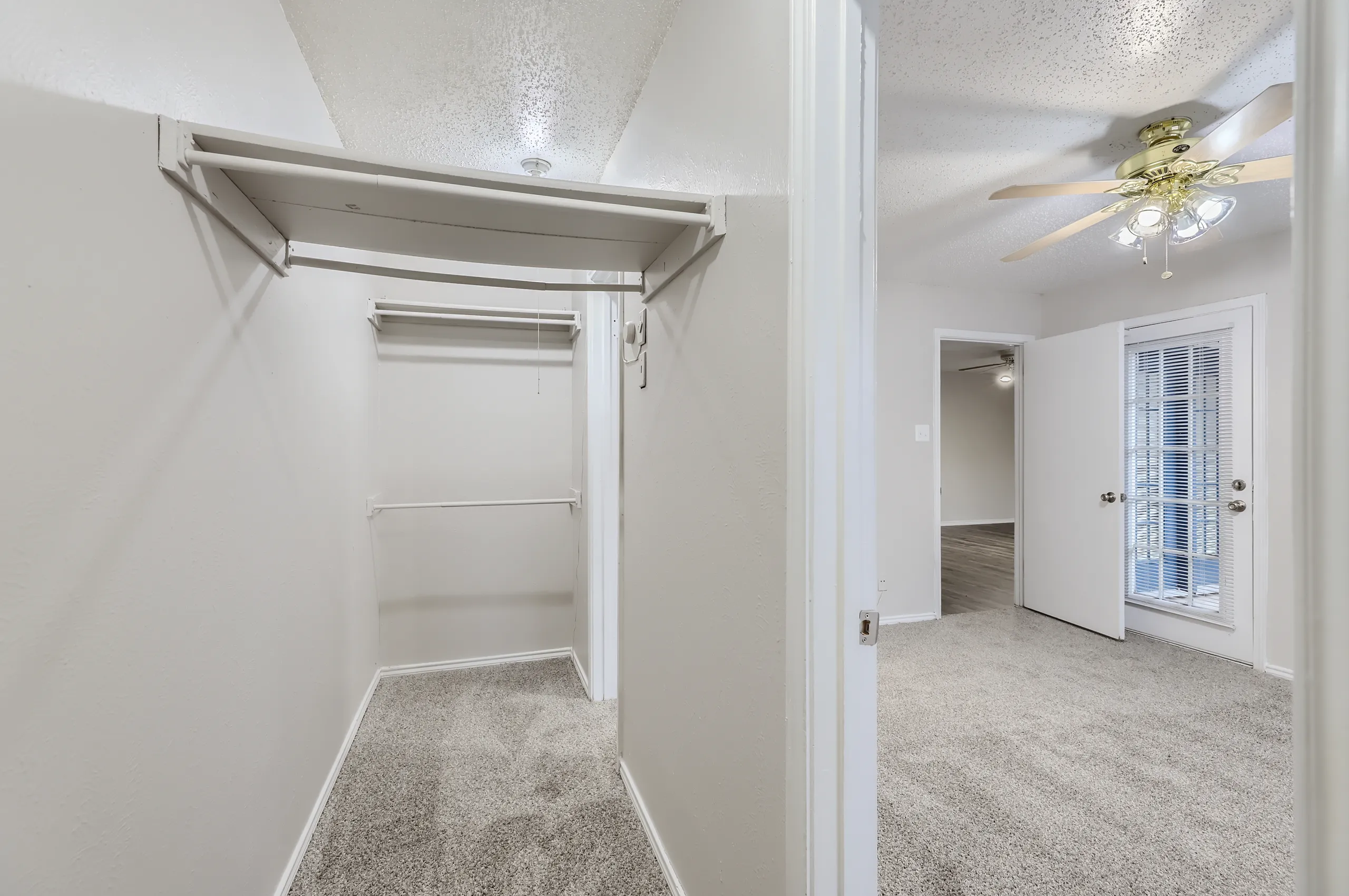 Walk-in closet with built-in shelving and hanging rod storage
