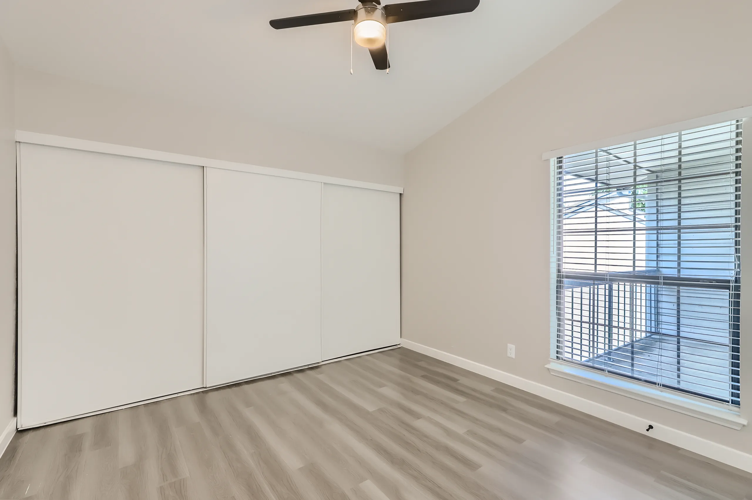 Bedroom with sliding closet doors and large window