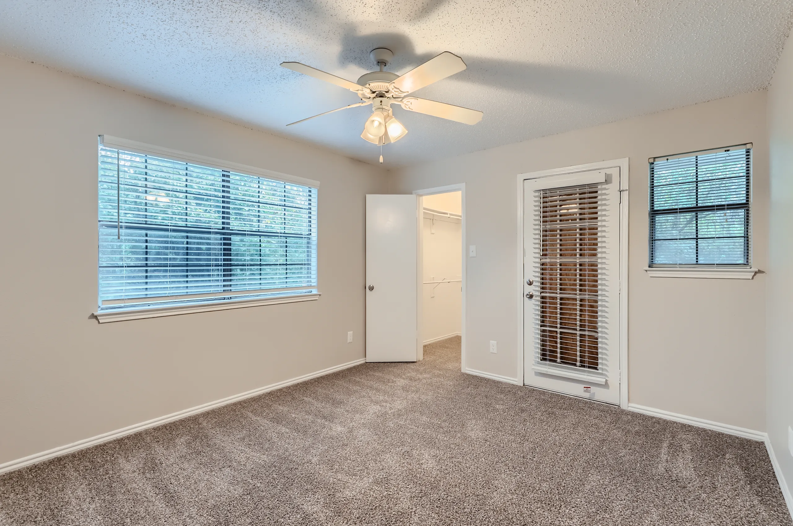 Bedroom with walk-in closet and private patio door