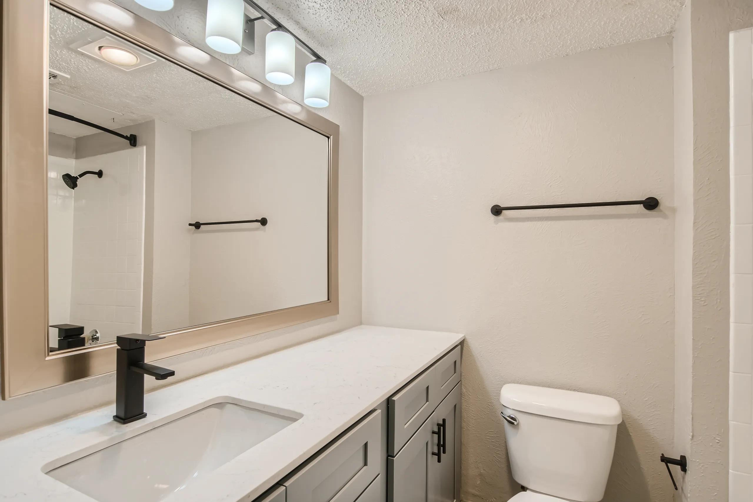 Renovated primary bathroom with quartz vanity and matte black fixtures