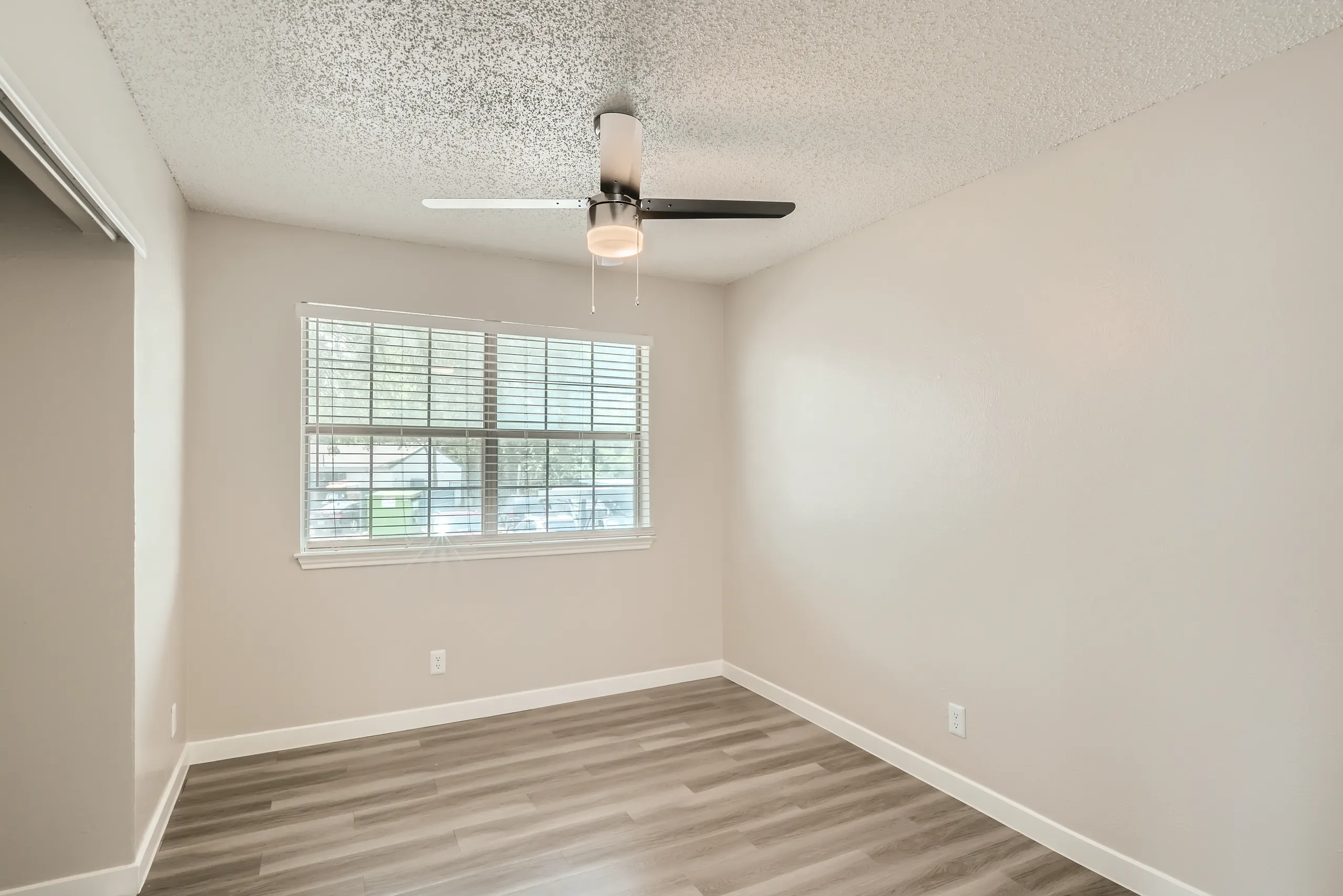Bedroom with wood-look flooring and large window