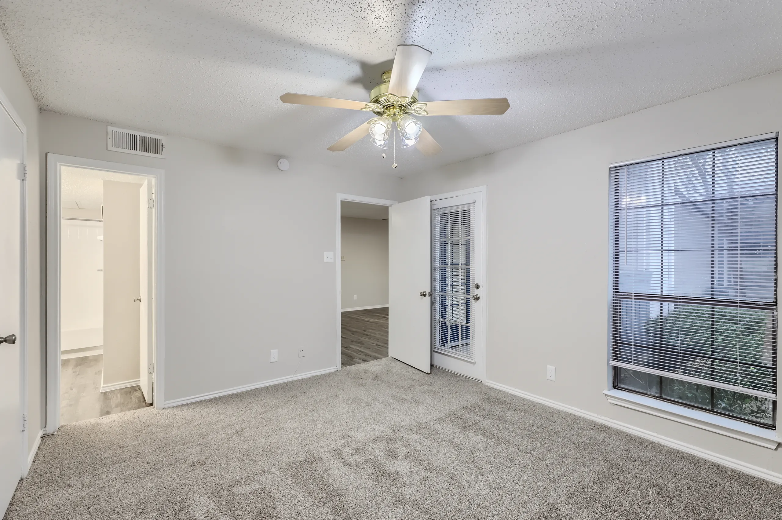 Primary bedroom with private balcony access and and en-suite bathroom access