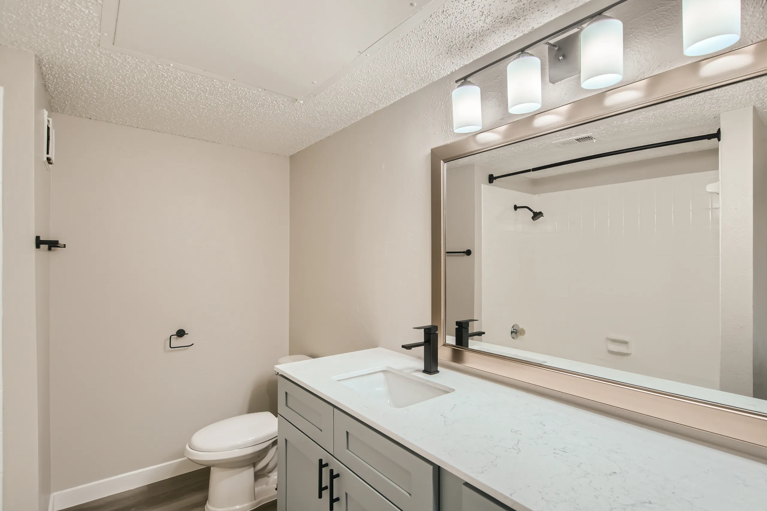 Renovated bathroom with quartz vanity and matte black fixtures