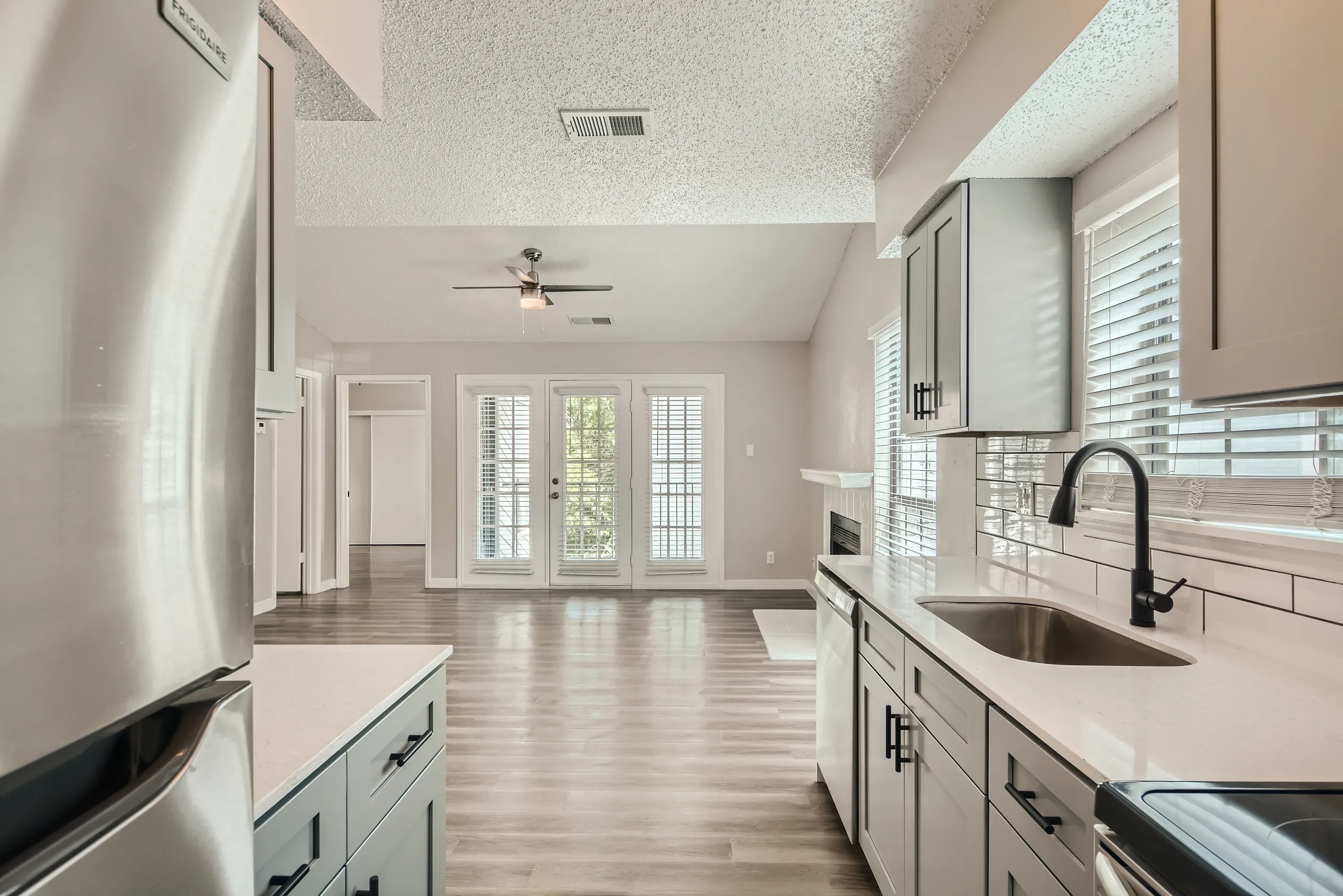Renovated kitchen with matte black fixtures, subway tile, and open living room view