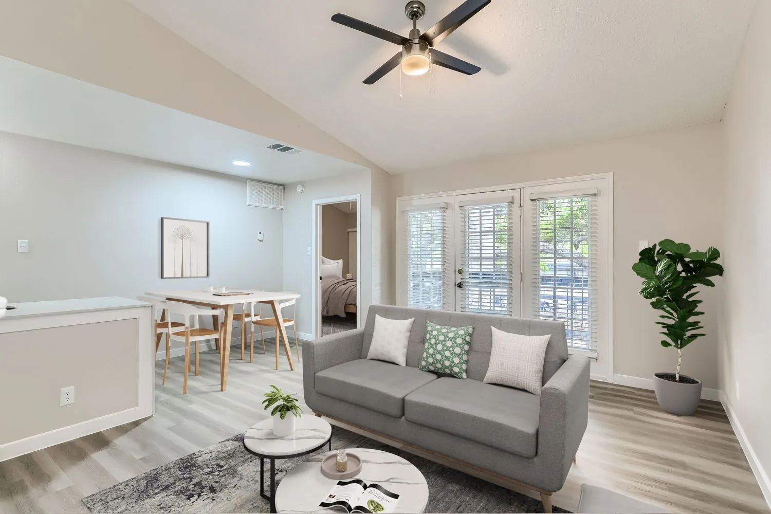 Renovated living room with vaulted ceiling, French doors, and open dining area