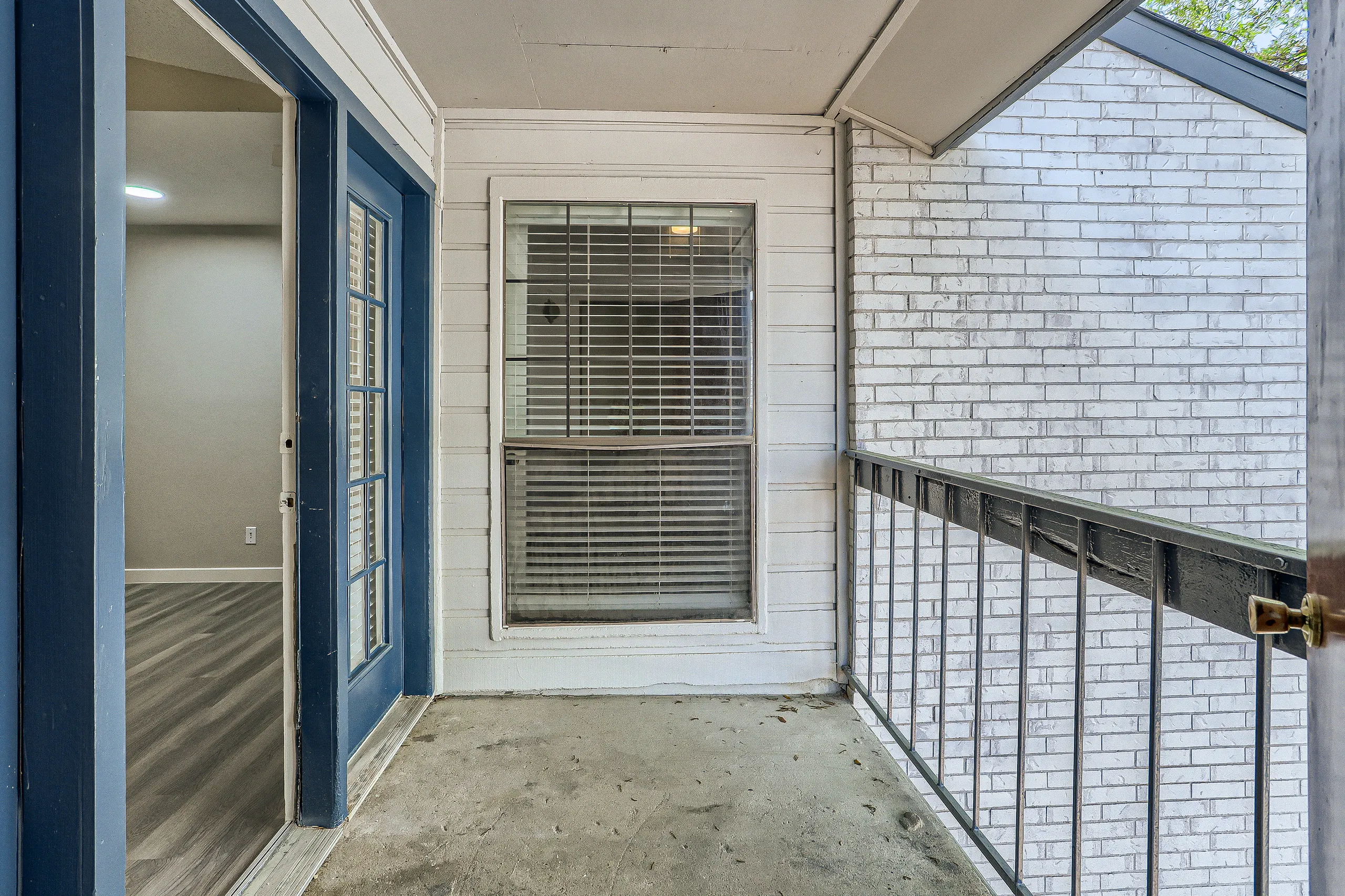 Private covered patio with French door entry and brick exterior