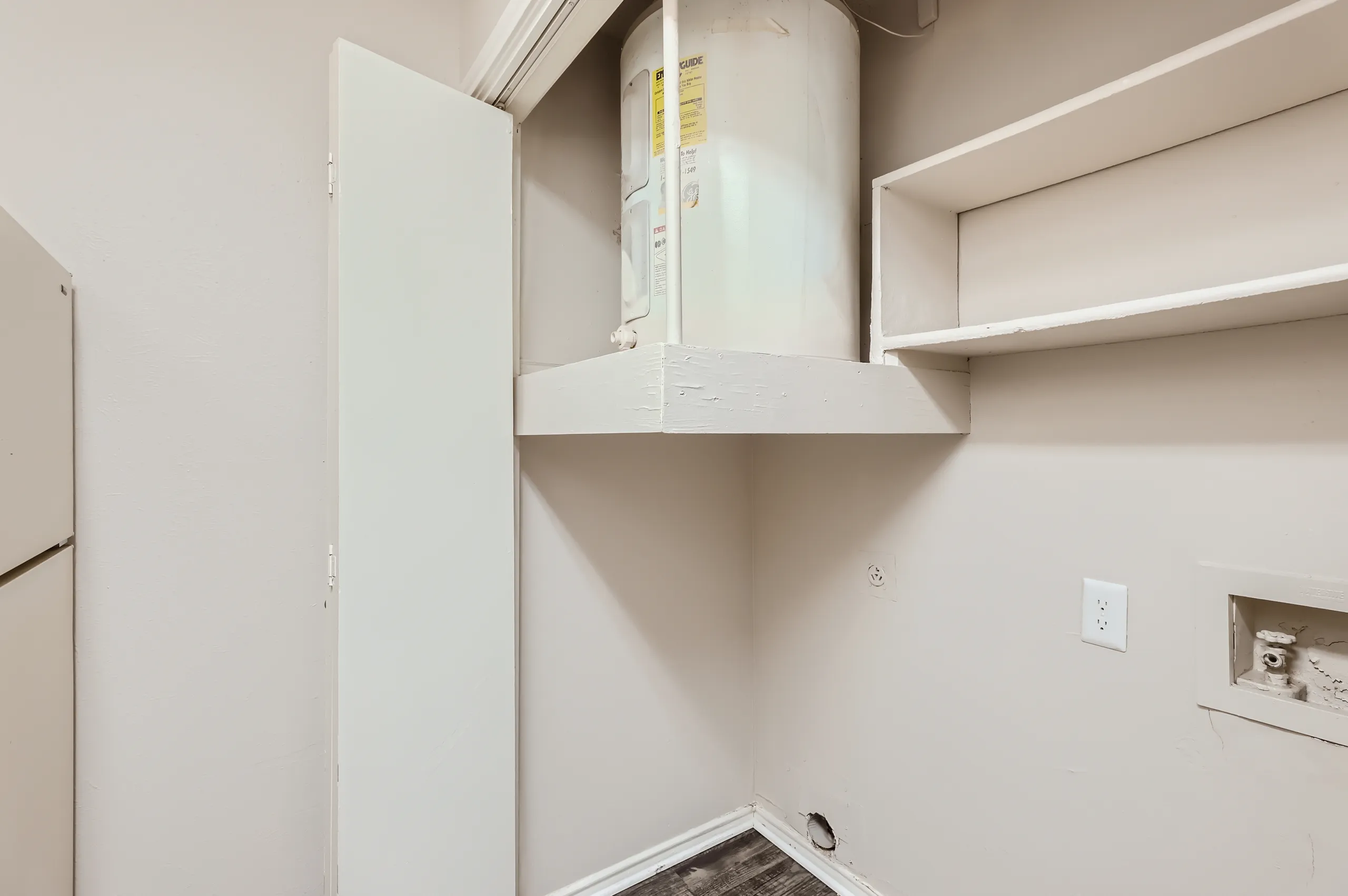 In-unit laundry closet with water heater and connections for washer and dryer