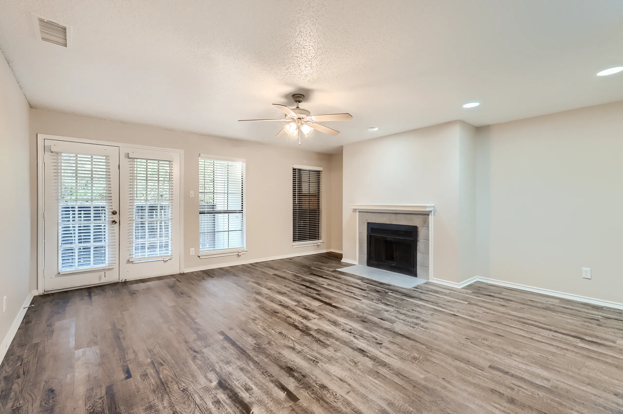 Living room with tiled fireplace and French door access