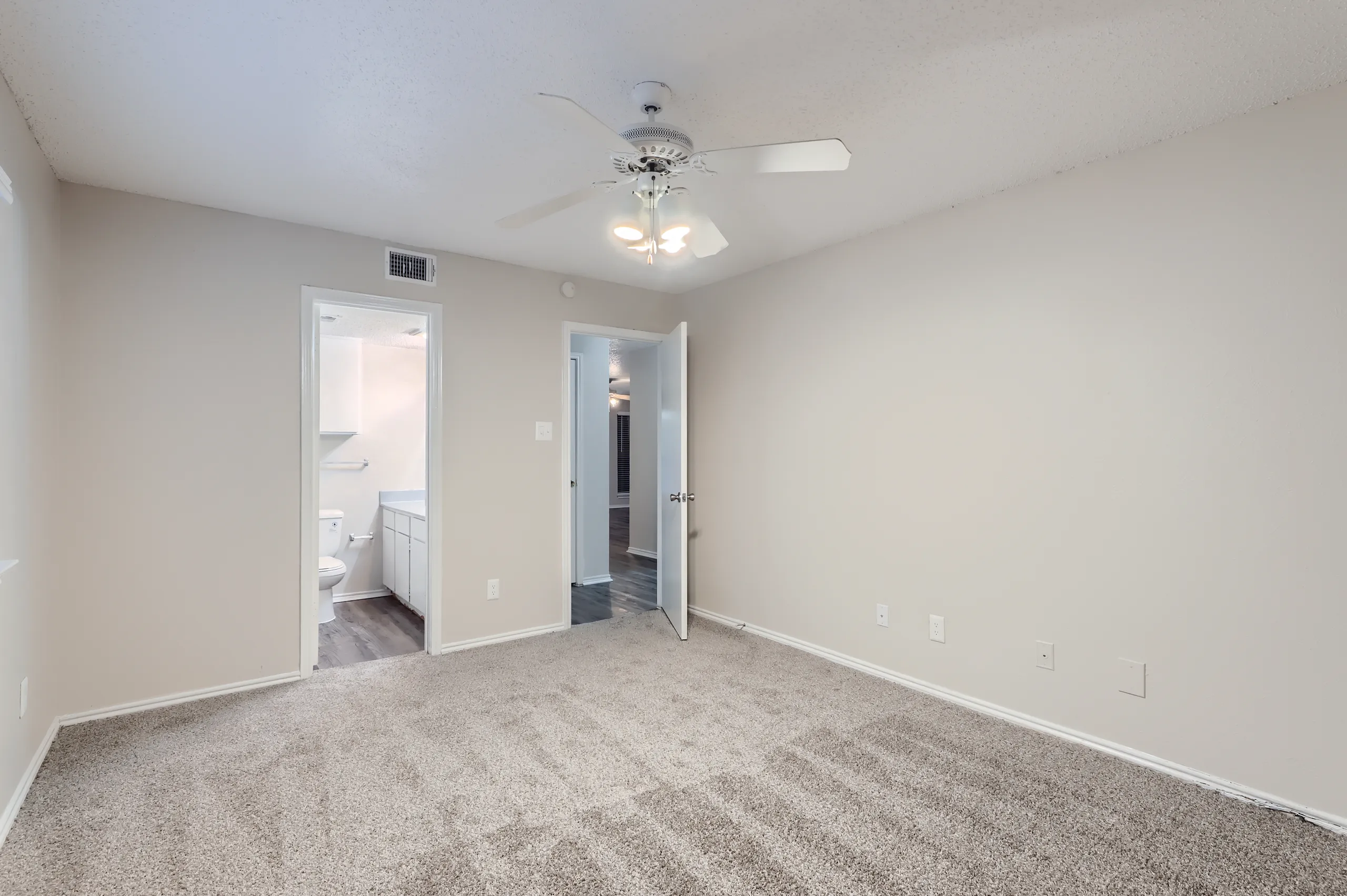 Primary bedroom with en-suite bathroom access and hallway view