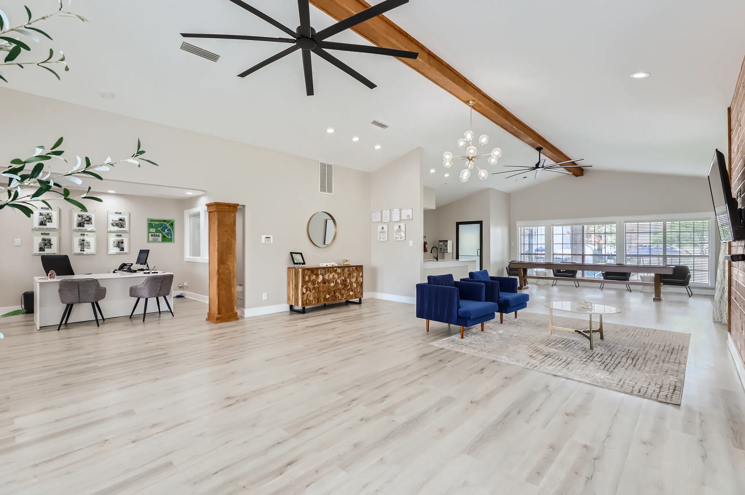 Clubhouse interior with leasing desk, lounge seating, and game area