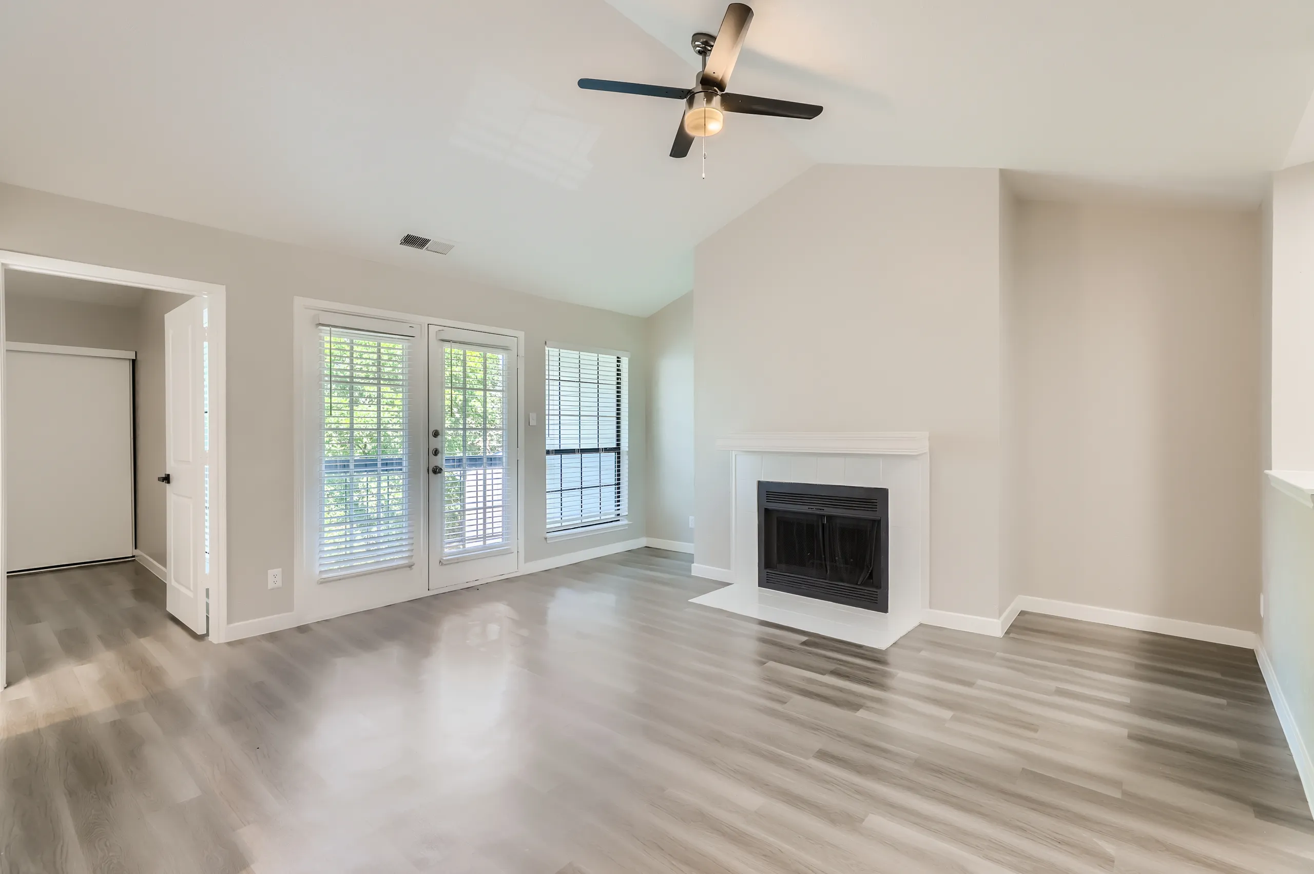 Living room with tiled fireplace and French door access