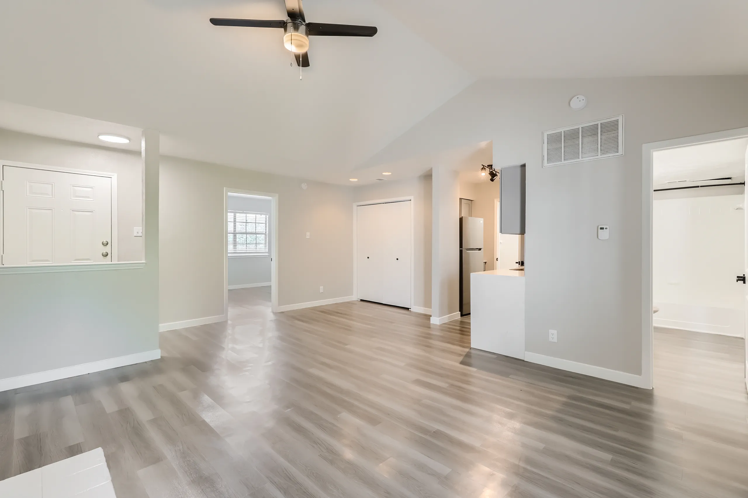 Open living room with entry door, closet, and kitchen view