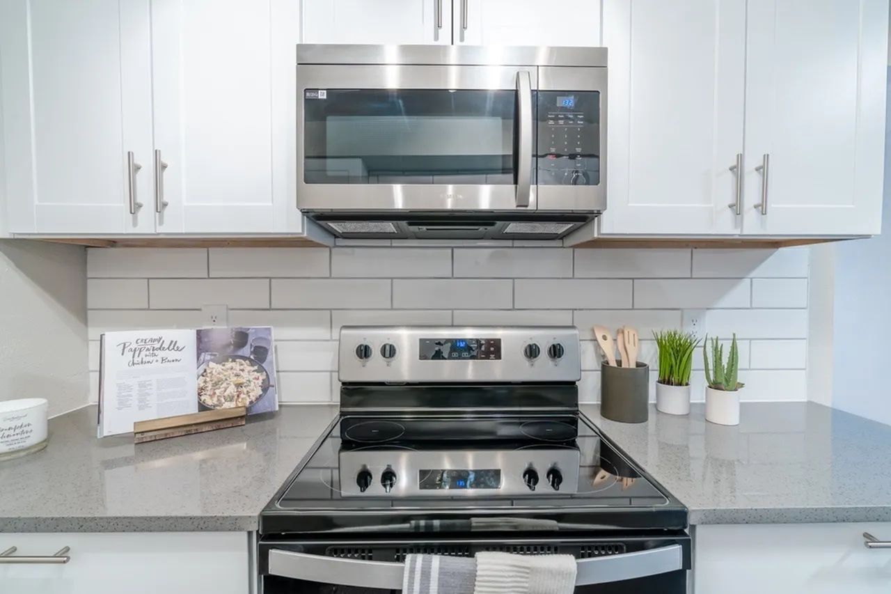 Kitchen, white shaker cabinetry, gray quartz countertops, stainless steel appliances