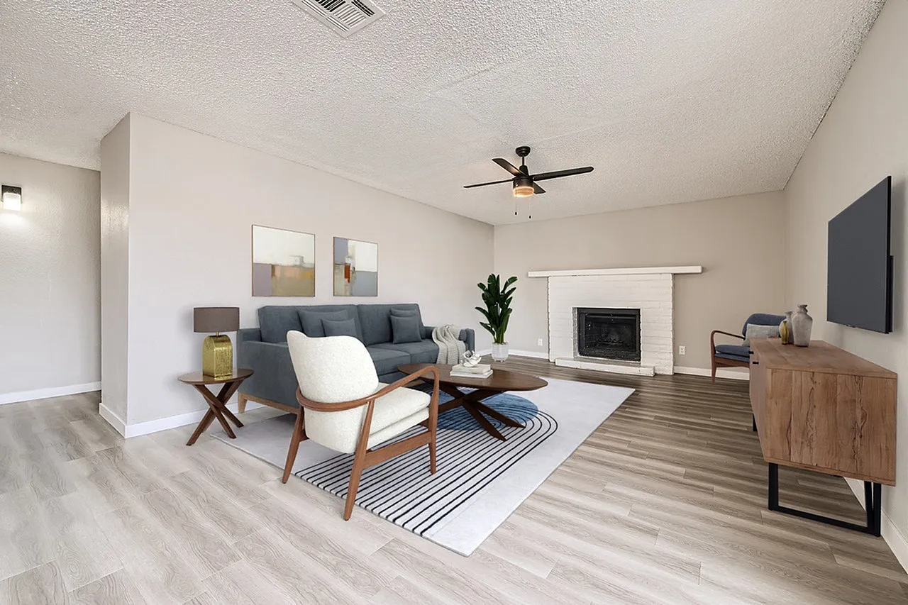 Living room, wood-style plank flooring, gray sofa, fireplace, ceiling fan