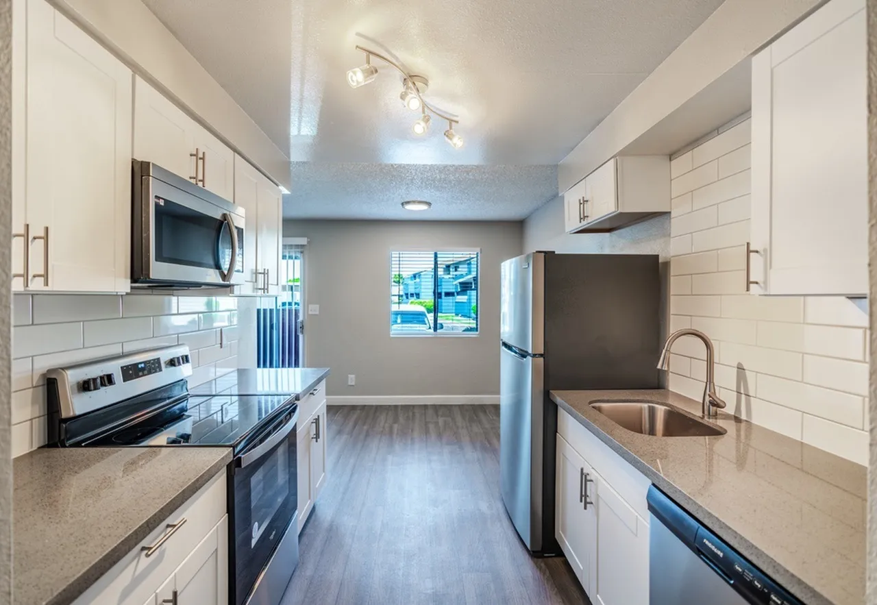 Kitchen, white shaker cabinetry, quartz countertops, stainless appliances, wood-style plank flooring