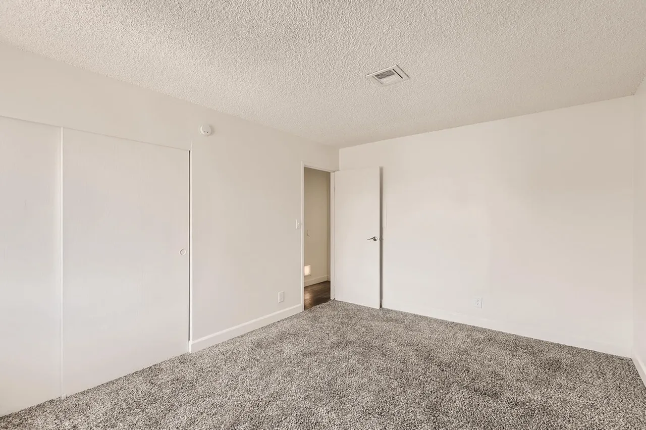 Bedroom, gray carpet flooring, built-in closets, white walls